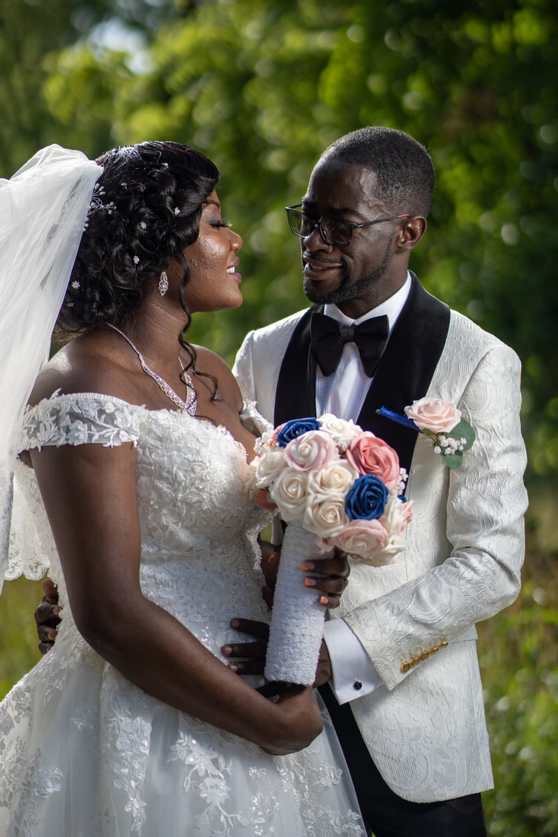 Man in Black Suit Holding Woman in White Wedding Dress